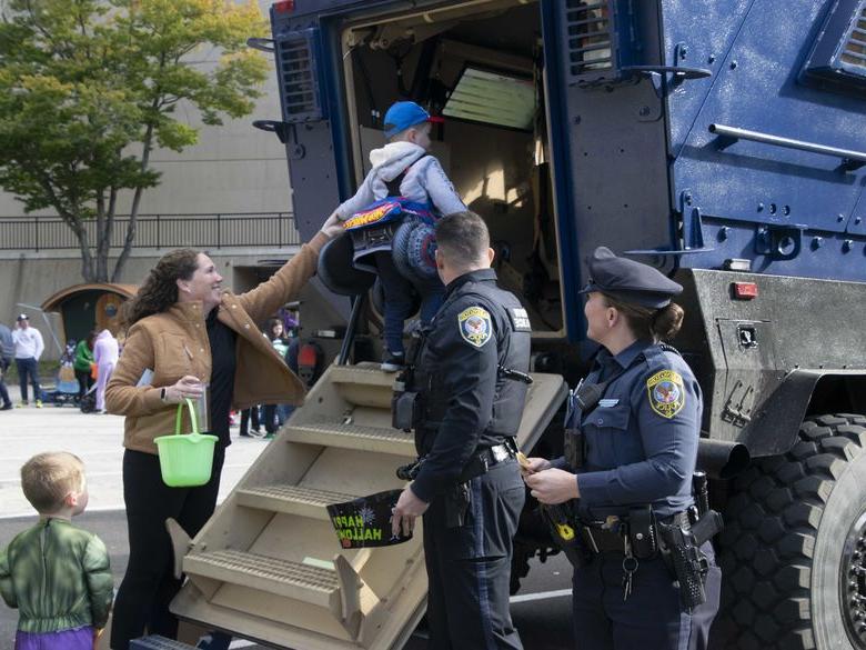 child climbing stairs into police truck 