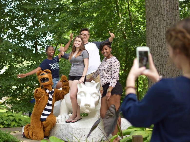 Students pose for a photo by the Lion Shrine